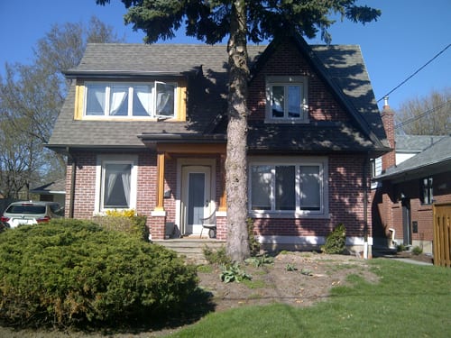 Red brick home with dormer and dark eavestrough system