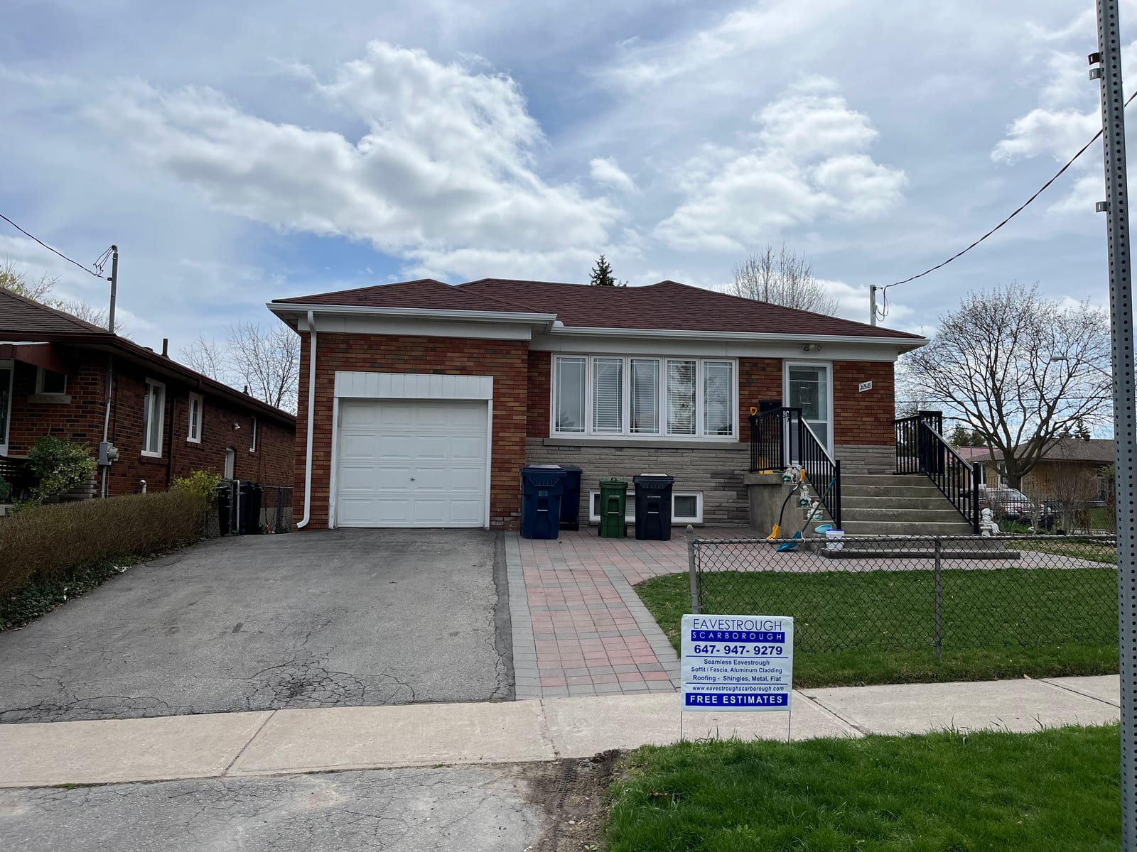 Brick home with new eavestroughs and free estimates sign